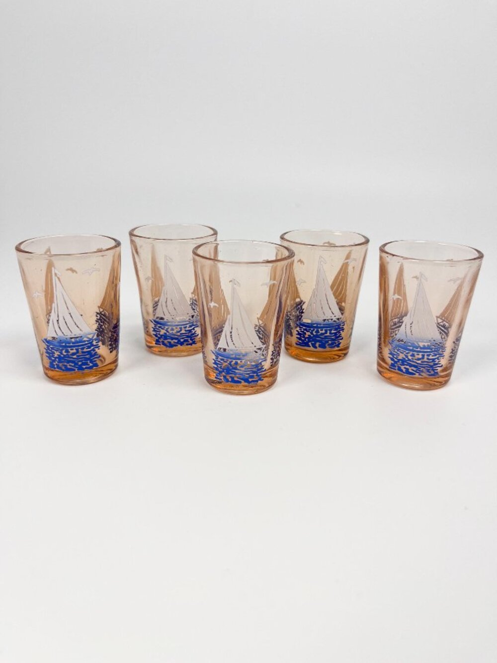 Vintage mini peach coloured shot glasses with sailboat motif